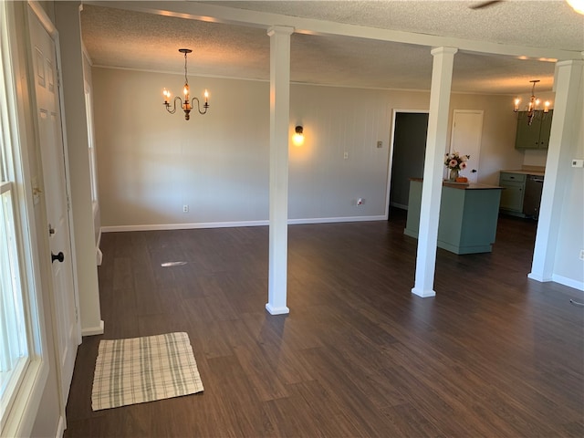 unfurnished room with dark wood-type flooring, crown molding, a chandelier, a textured ceiling, and decorative columns