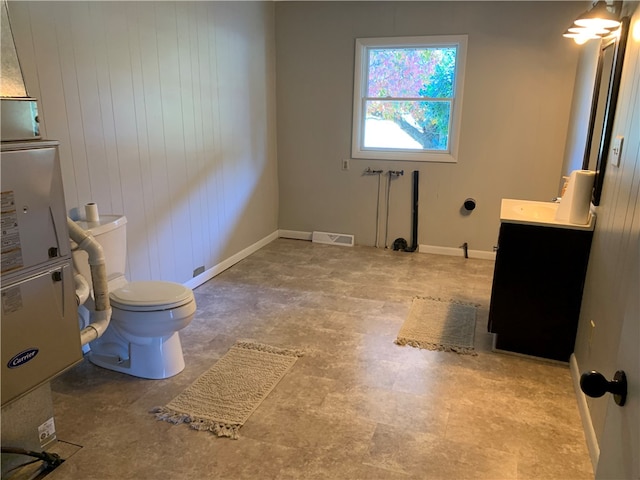 bathroom with vanity, toilet, and wooden walls