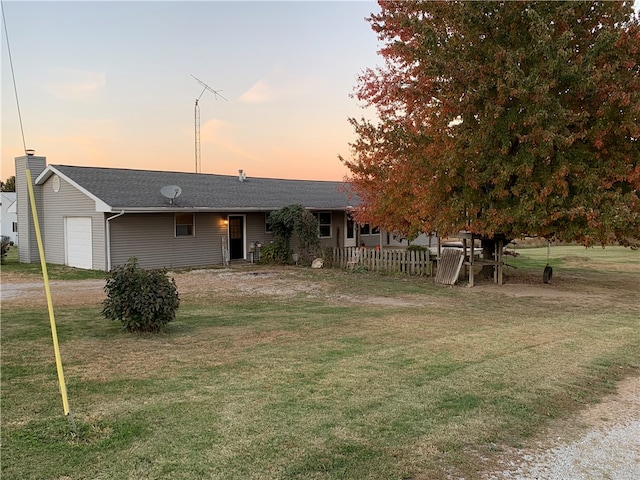 exterior space featuring a garage and a lawn