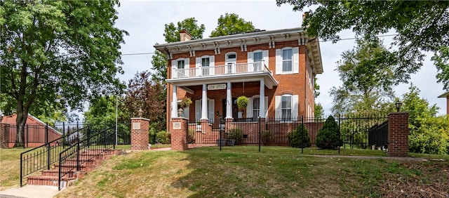 italianate home with covered porch, a balcony, and a front yard