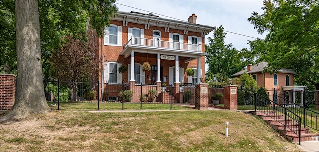 italianate-style house with a front yard, a porch, and a balcony