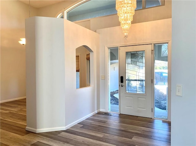 foyer featuring a chandelier, baseboards, and wood finished floors