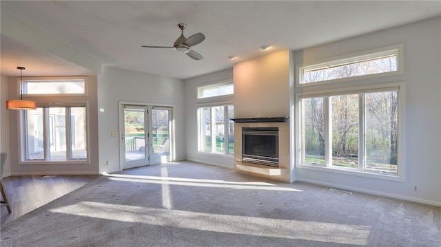 unfurnished living room featuring baseboards, visible vents, and a fireplace with raised hearth