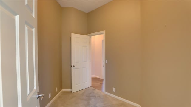 empty room featuring light carpet and baseboards