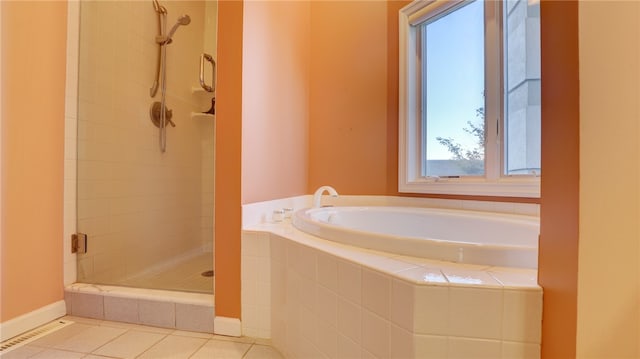 full bathroom featuring a garden tub, a stall shower, tile patterned flooring, and baseboards