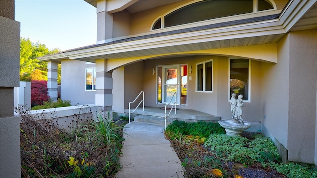 entrance to property with a porch and stucco siding