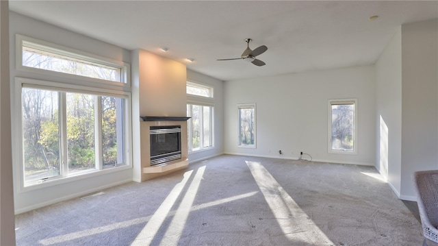 unfurnished living room with carpet, a tile fireplace, visible vents, and baseboards