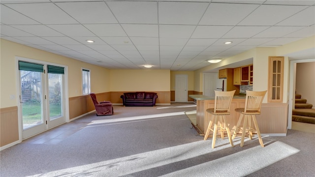 bar featuring light colored carpet, a wainscoted wall, stairway, white fridge, and recessed lighting