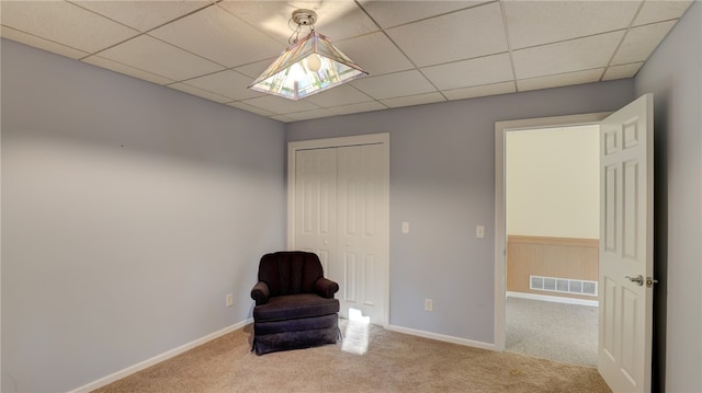 unfurnished room with carpet, visible vents, a paneled ceiling, and baseboards