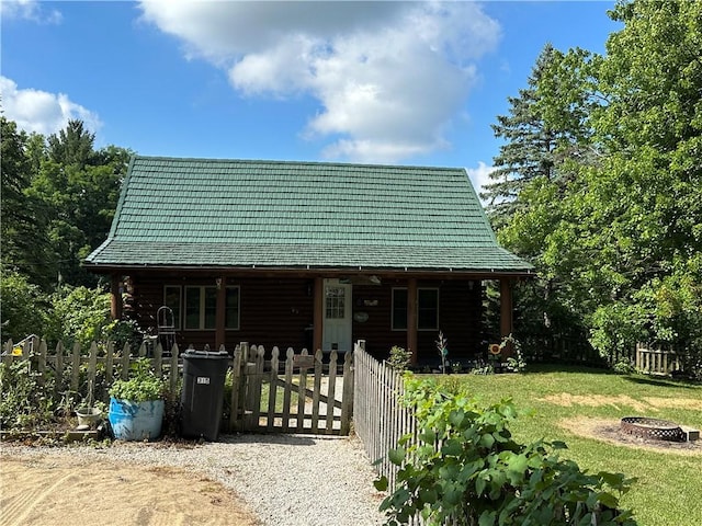 315 W Autumn Dr, Oakwood, IL 61858 - cabin with covered porch, a fire pit, a fenced front yard, log exterior, and a gate