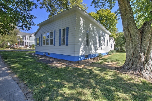 view of side of home with a yard