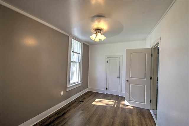 spare room with dark hardwood / wood-style flooring, ceiling fan, and crown molding