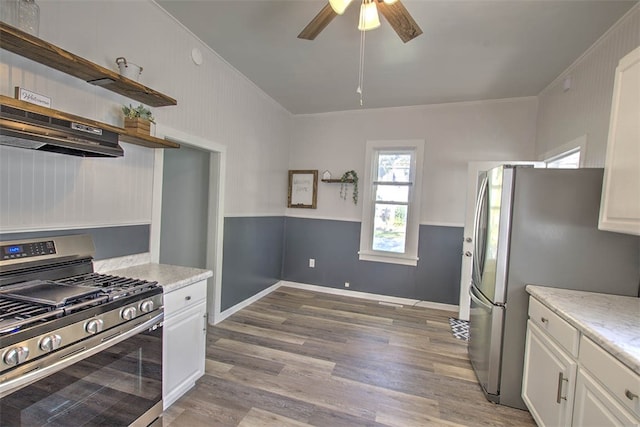 kitchen with appliances with stainless steel finishes, ventilation hood, crown molding, light hardwood / wood-style flooring, and white cabinetry