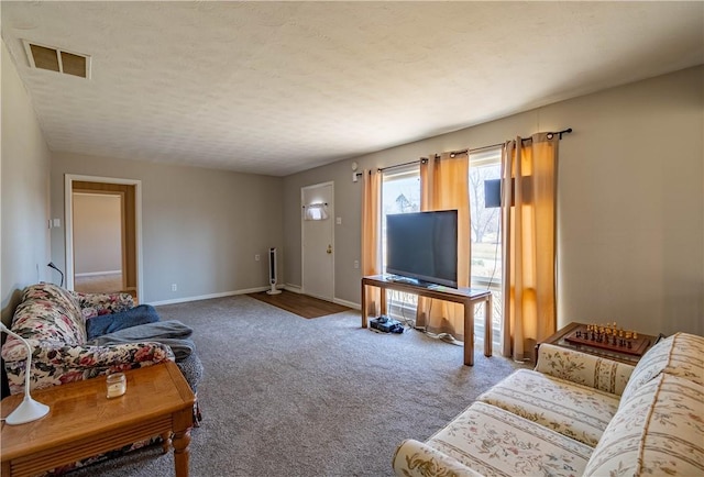 carpeted living room featuring visible vents, a textured ceiling, and baseboards