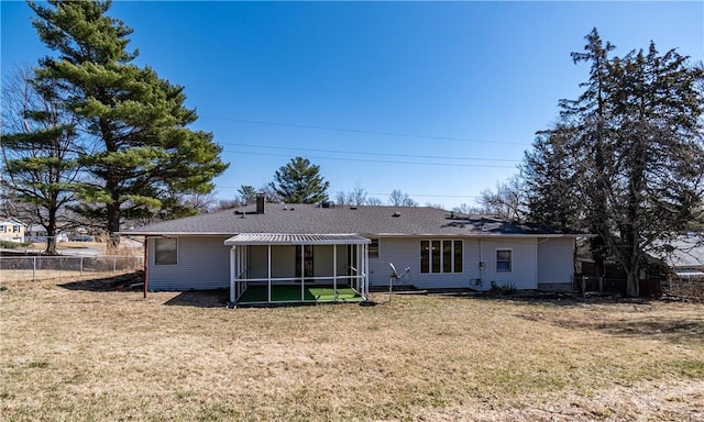 rear view of property featuring a lawn and fence