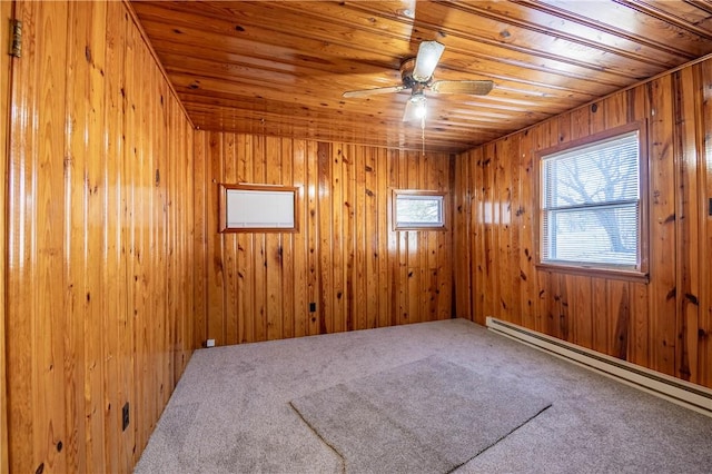 carpeted empty room with ceiling fan, a baseboard heating unit, wooden ceiling, and wood walls