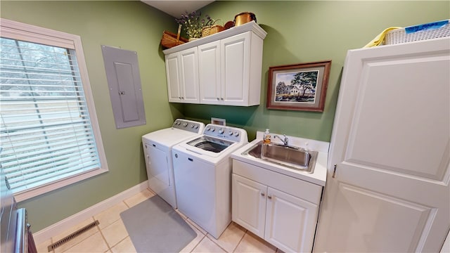 clothes washing area featuring sink, electric panel, cabinets, a healthy amount of sunlight, and separate washer and dryer