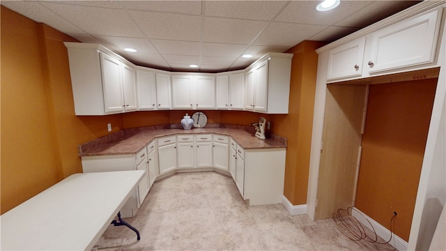 kitchen with white cabinetry and a drop ceiling