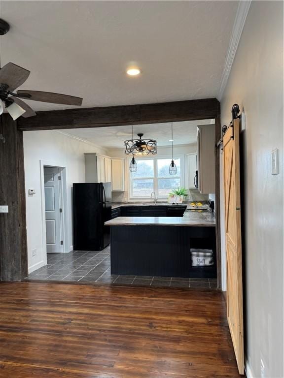 kitchen featuring freestanding refrigerator, dark wood-style flooring, beamed ceiling, and a barn door