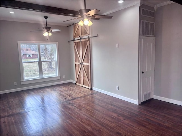 spare room with dark wood-style flooring, visible vents, a barn door, ceiling fan, and baseboards