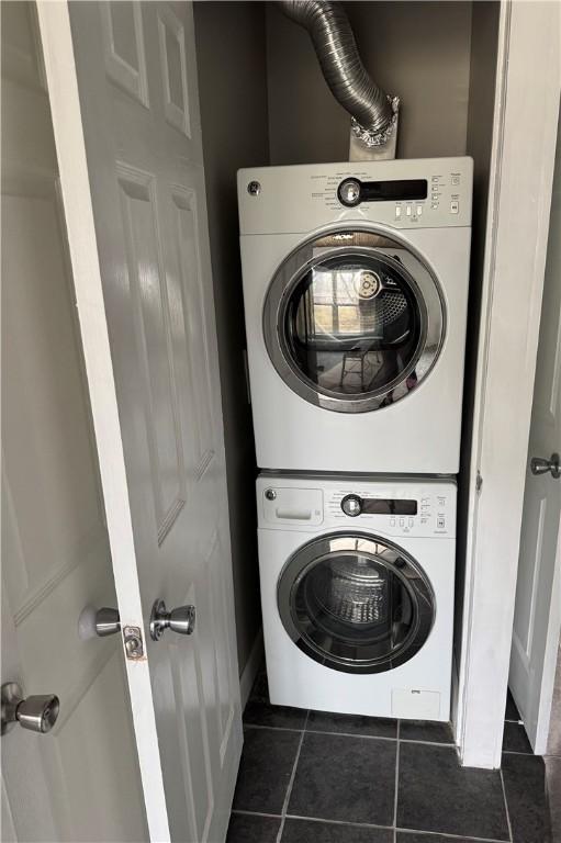 washroom featuring laundry area, tile patterned floors, and stacked washer / drying machine