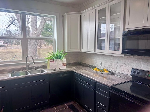 kitchen featuring glass insert cabinets, light countertops, black appliances, white cabinetry, and a sink