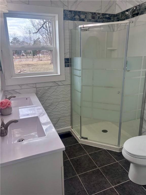 full bath featuring a sink, a shower stall, and double vanity