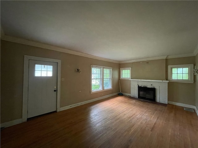 unfurnished living room featuring wood-type flooring, plenty of natural light, and crown molding