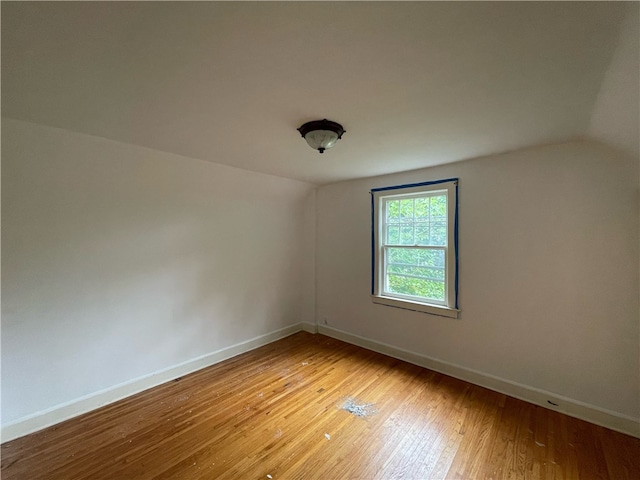 empty room featuring light wood-type flooring and lofted ceiling