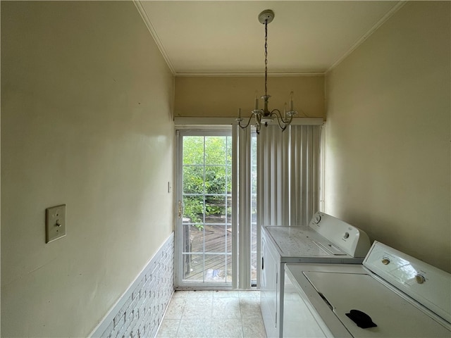 clothes washing area with washer and dryer, light tile patterned floors, crown molding, and an inviting chandelier