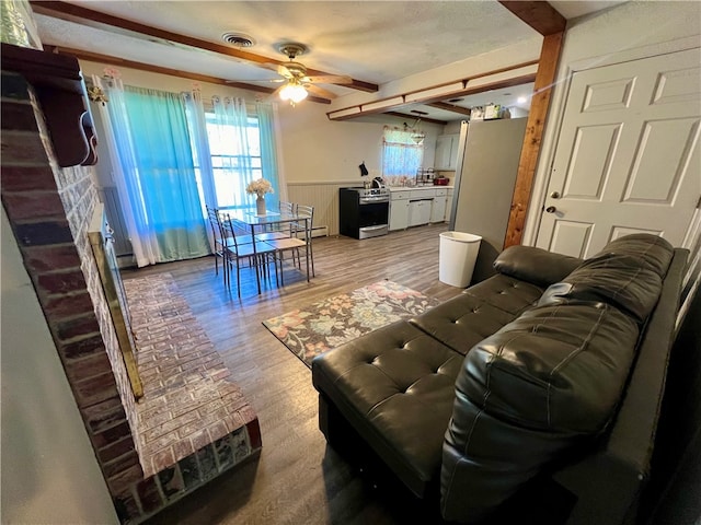 living room with hardwood / wood-style flooring, ceiling fan, and wood walls