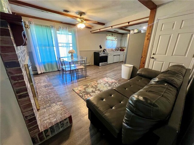 29 Homestead Dr, Newton, IL 62448 - living room featuring ceiling fan, healthy amount of natural light, light wood-style floors, wainscoting, and beamed ceiling