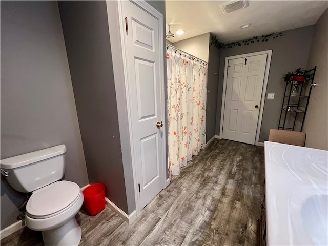 bathroom with hardwood / wood-style floors and toilet