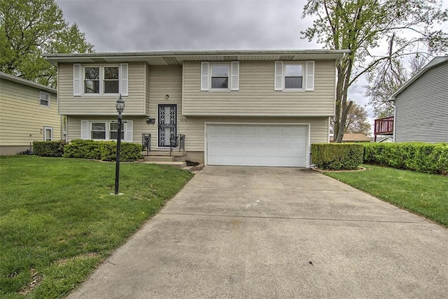 raised ranch featuring concrete driveway, a front yard, and a garage