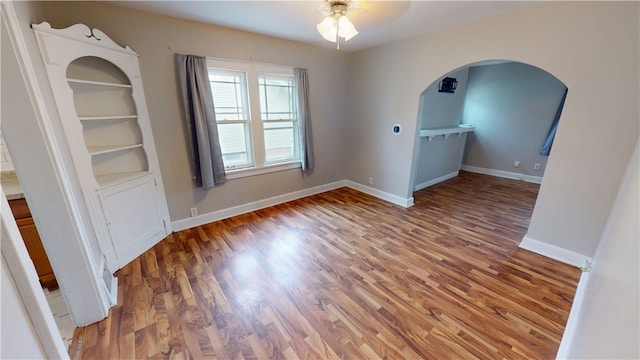 unfurnished room featuring dark wood-type flooring and ceiling fan