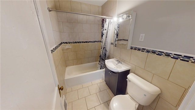 full bathroom featuring tile walls, vanity, tile patterned floors, toilet, and shower / bath combo with shower curtain