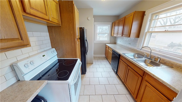 kitchen with tasteful backsplash, light tile patterned floors, sink, and black appliances