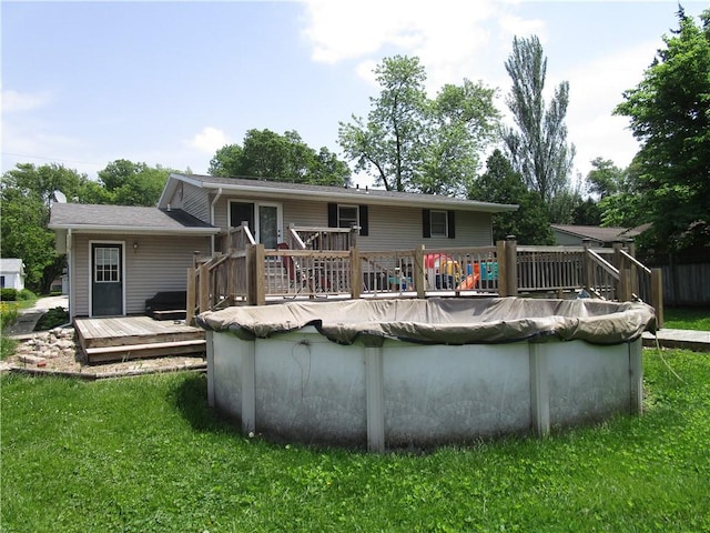 205 Franklin St, Pana, IL 62557 - back of house featuring a deck, a covered pool, and a yard