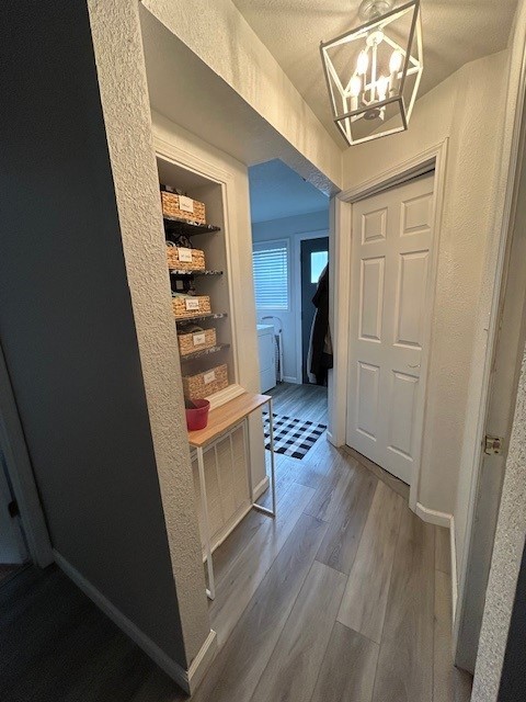3221 E Lake Paradise Rd, Mattoon, IL 61938 - hallway featuring wood finished floors, a textured wall, and a chandelier
