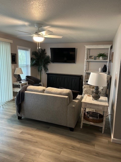 3221 E Lake Paradise Rd, Mattoon, IL 61938 - living area featuring ceiling fan, light wood-type flooring, and a textured ceiling