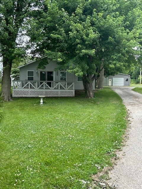 3221 E Lake Paradise Rd, Mattoon, IL 61938 - view of front of house with a front lawn, an outbuilding, driveway, and a garage