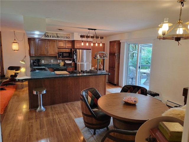 517 W Union St, Nokomis, IL 62075 - kitchen featuring freestanding refrigerator, black microwave, dark countertops, and light wood-style flooring