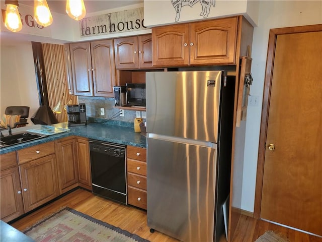 517 W Union St, Nokomis, IL 62075 - kitchen featuring freestanding refrigerator, black dishwasher, light wood-style floors, dark countertops, and brown cabinets