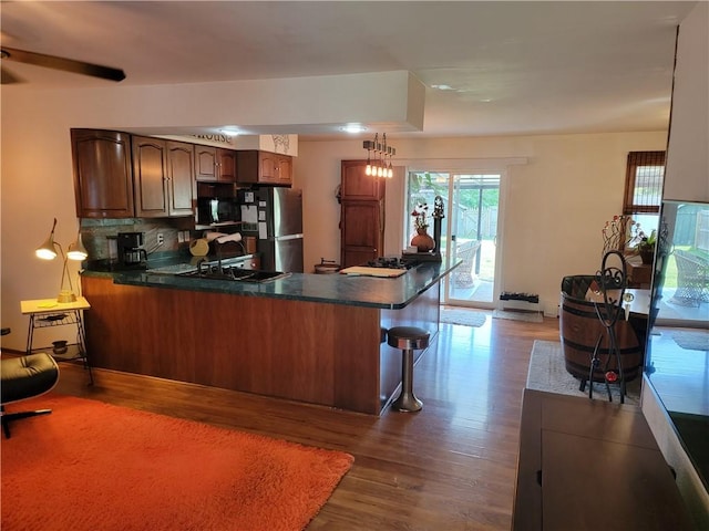 517 W Union St, Nokomis, IL 62075 - kitchen with freestanding refrigerator, a peninsula, wood finished floors, and dark countertops