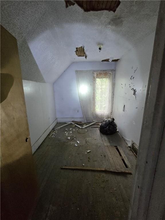 bonus room with a textured ceiling and vaulted ceiling