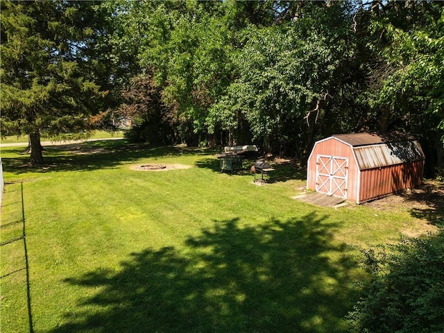 602 Maple Dr, Catlin, IL 61817 - view of grassy yard with a storage unit and a fire pit