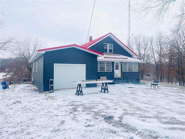 snow covered property with a garage