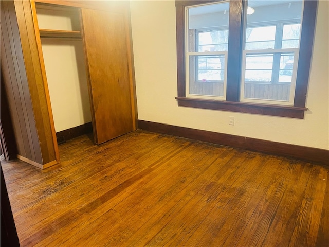 unfurnished bedroom with wood-type flooring and a closet