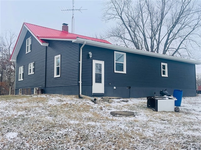 view of snow covered rear of property