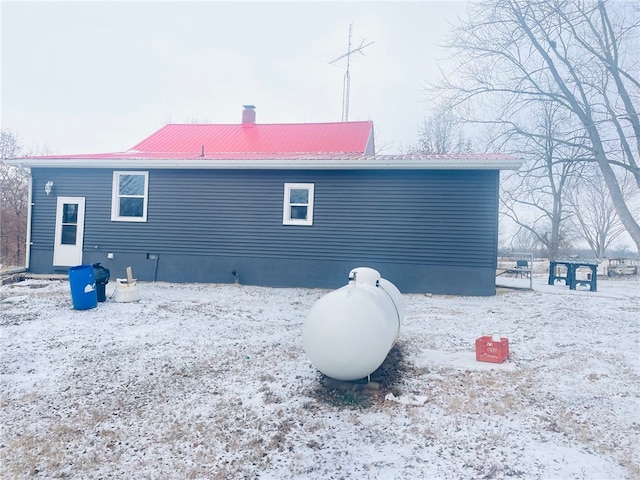 view of snow covered rear of property